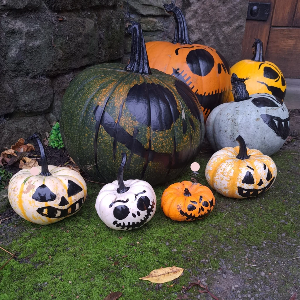 Pumpkins infront of gate with faces on them
