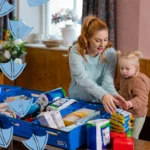 mum and daughter in a derbyshire food banks packing food boxes