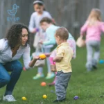 kids playing easter egg hunt in derbyshire with a mum passing an egg to a young child