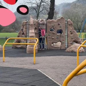 eliza climbing on the climbing wall at bakewell derbyshire dales playground